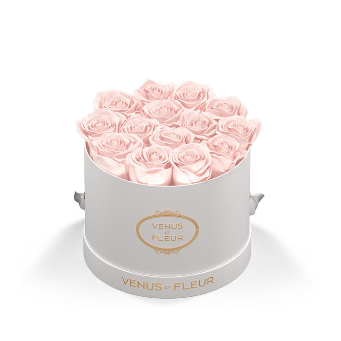 Round white box with light pink roses arranged inside, labeled 'VENUS ET FLEUR' on the front and base.